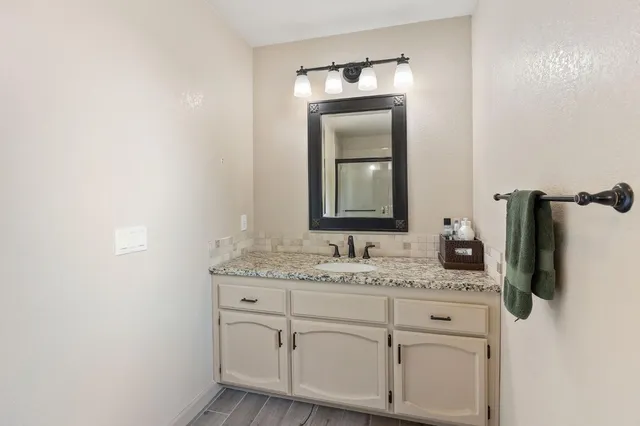 a bathroom with a granite countertop sink and a mirror
