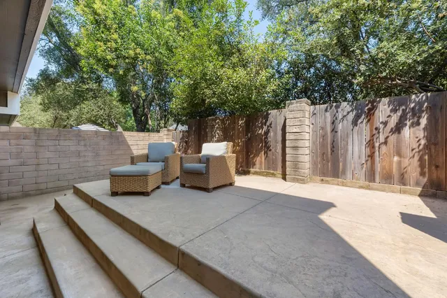 a view of backyard with couches and white fence