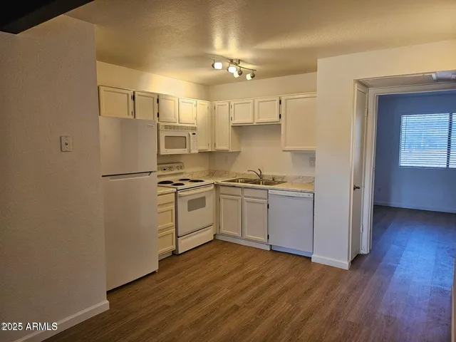 a kitchen with white cabinets and white appliances