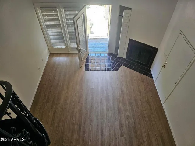 a view of a hallway with wooden floor and stairs
