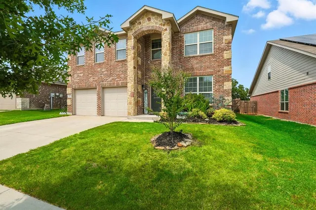 a front view of a house with a yard and potted plants