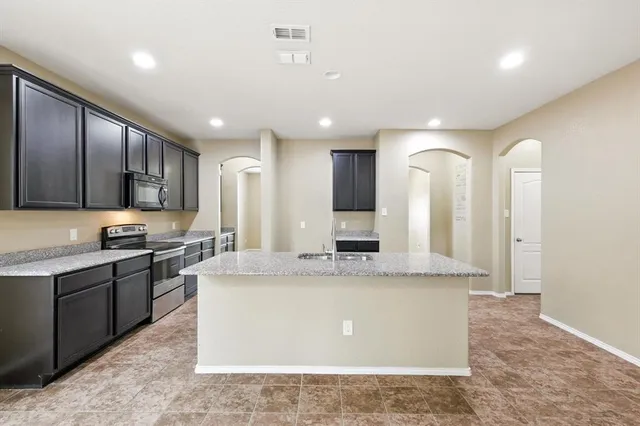 a large kitchen with stainless steel appliances granite countertop a large counter top and a stove