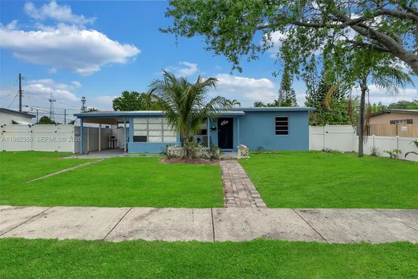 a front view of a house with a garden and trees