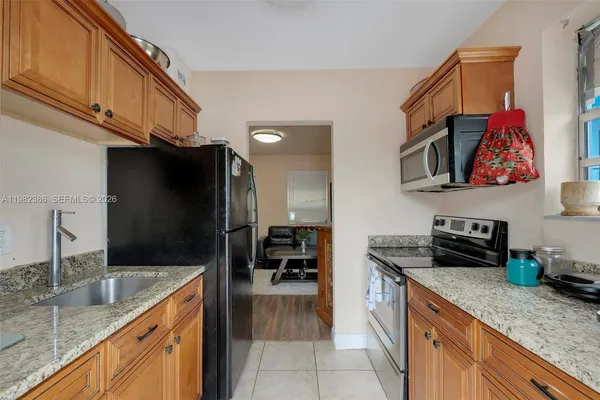 a kitchen with stainless steel appliances granite countertop a sink and a refrigerator