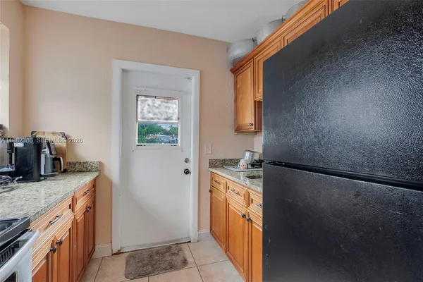 a kitchen with granite countertop a sink stove and refrigerator