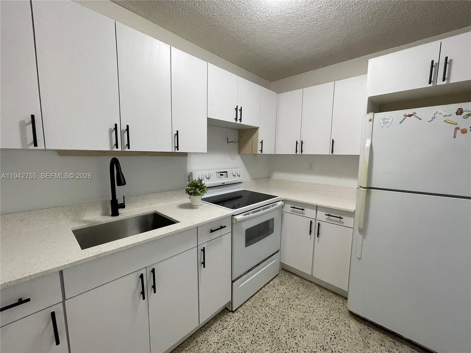 142 Southwest 18th Avenue, Unit 19 Miami, FL 33135 - Photo 1 of 28 a kitchen with a sink and a refrigerator