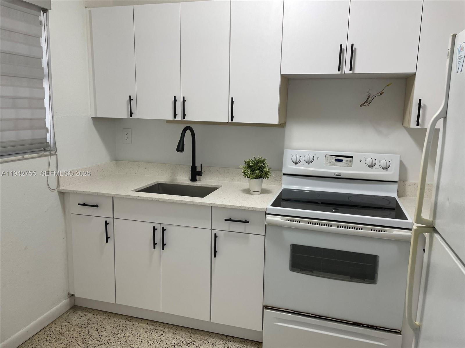 142 Southwest 18th Avenue, Unit 19 Miami, FL 33135 - Photo 2 of 28 a kitchen with white cabinets and white appliances