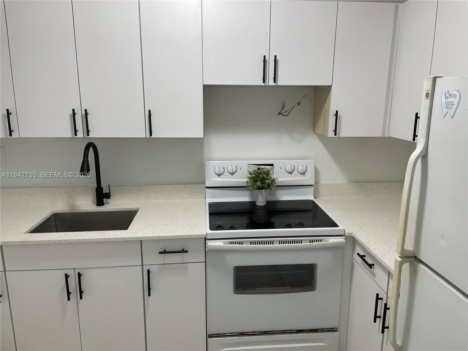 142 Southwest 18th Avenue, Unit 19 Miami, FL 33135 - Photo 3 of 28 a kitchen with a stove and a white cabinet
