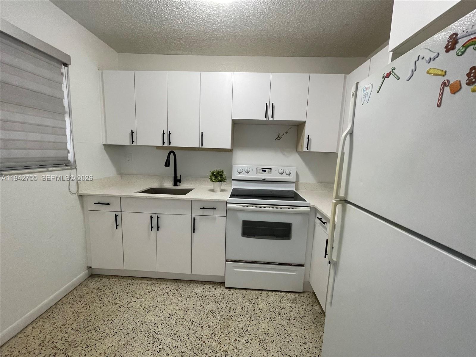 142 Southwest 18th Avenue, Unit 19 Miami, FL 33135 - Photo 5 of 28 a kitchen with a white cabinets and white appliances