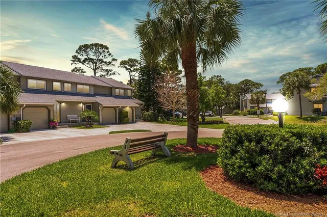 a front view of a house with garden and trees