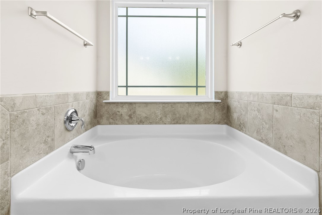 216 Meherrin Loop Raeford, NC 28376 - Photo 18 of 38 a white bath tub sitting in a bathroom next to a window