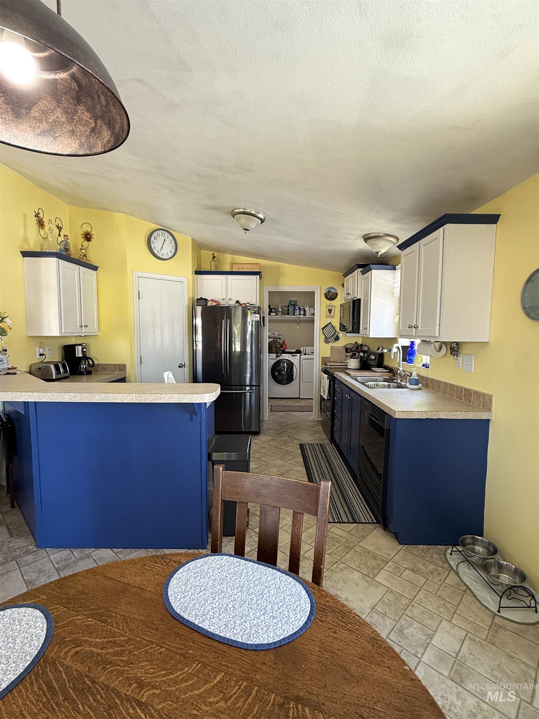 2750 Alden Road, Unit 12 12 Fruitland, ID 83619 - Photo 13 of 38 Kitchen featuring two-tone cabinetry with blue bases and white uppers, light-toned countertops, and a tile-patterned floor