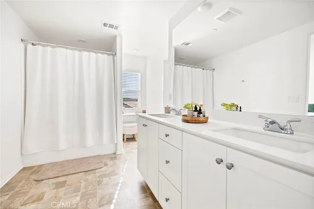 a bathroom with a double vanity sink and a mirror
