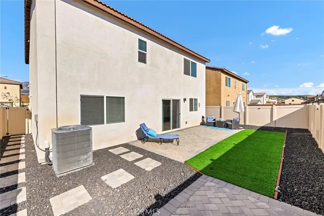 a view of a house with backyard and sitting area