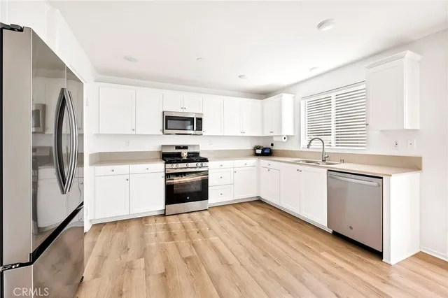 a kitchen with granite countertop white cabinets and stainless steel appliances