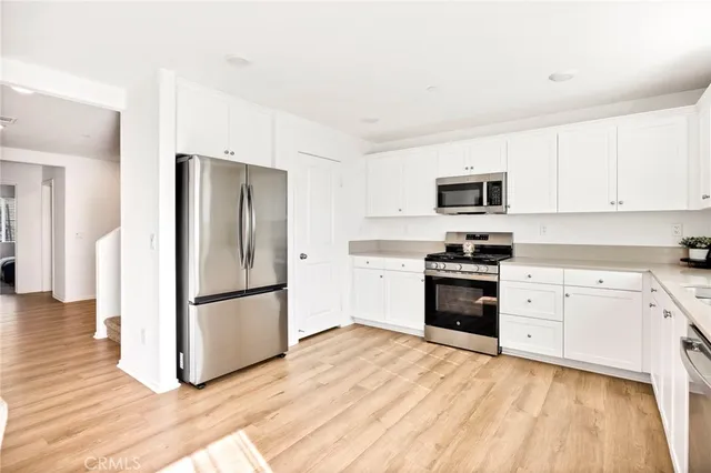 a kitchen with granite countertop a refrigerator stove and microwave