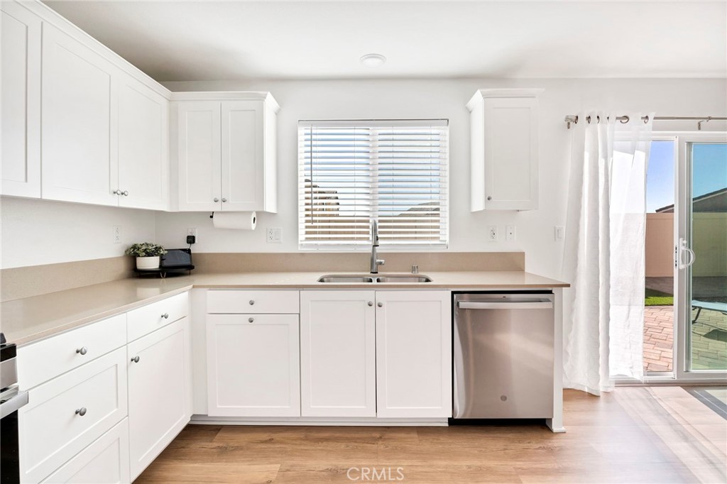 1489 Goldenbrush Way Banning, CA 92220 - Photo 6 of 38 a kitchen with granite countertop white cabinets and white appliances