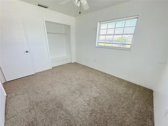 an empty room with windows and closet