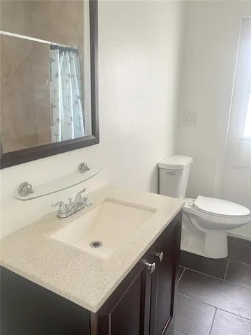 a bathroom with a sink a toilet and mirror