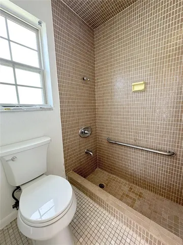 a bathroom with a toilet and a shower