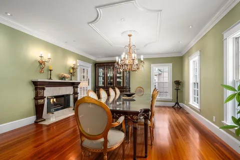 a view of a dining room with furniture a chandelier and wooden floor