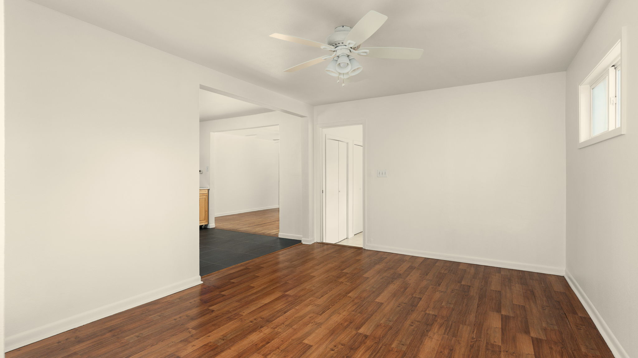 206 East Skyview Road Austin, TX 78752 - Photo 14 of 32 Rich wood flooring grounds this airy interior space with a distinct ceiling fan and a window for natural light.