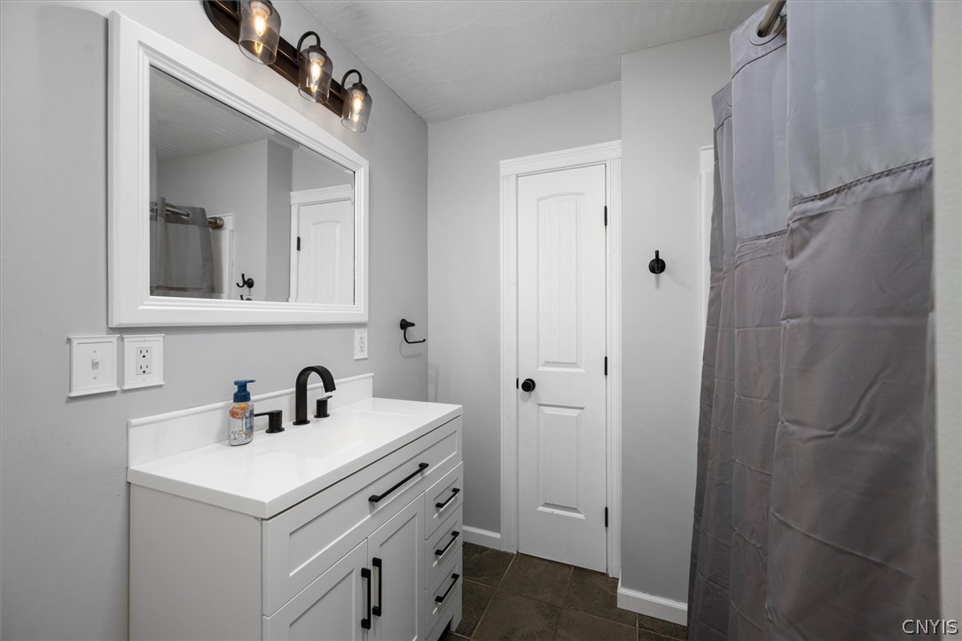 1322 Sawmill Road Sangerfield, NY 13480 - Photo 25 of 50 Modern finishes define this crisp, neutral bathroom complete with a sleek single vanity and tile flooring.