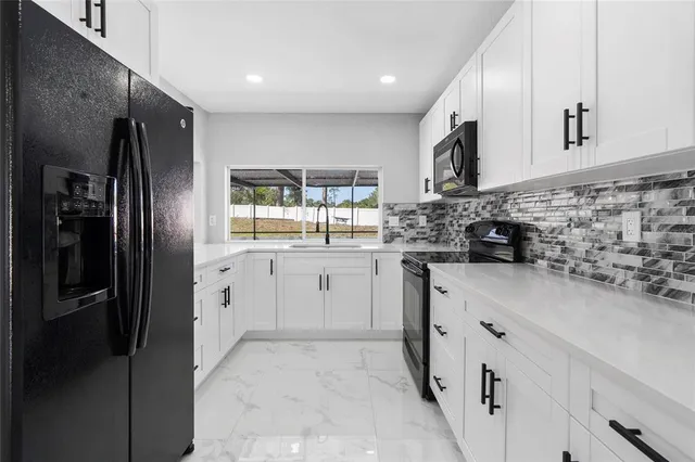a kitchen with stainless steel appliances a refrigerator sink and microwave