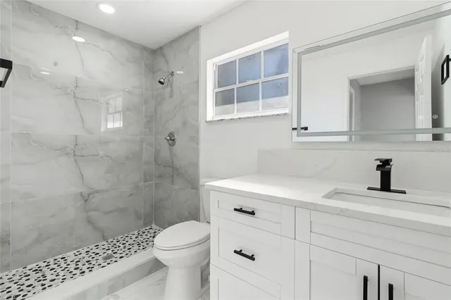 a bathroom with a sink a toilet and shower