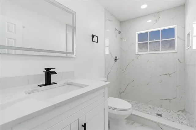 a bathroom with a sink a toilet and shower