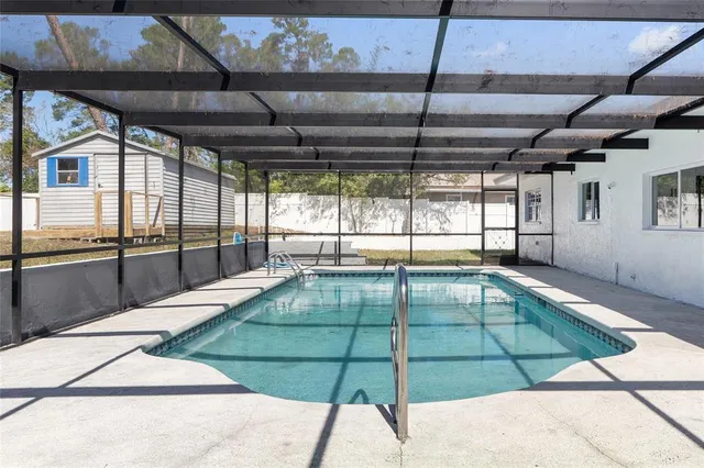 a white swimming pool with a balcony and furniture