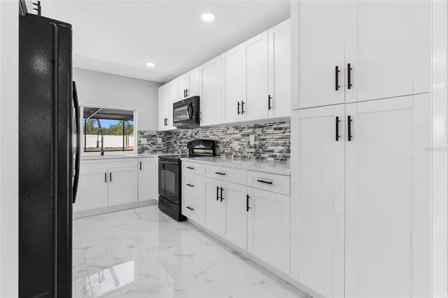 a kitchen with white cabinets and stainless steel appliances