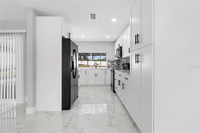 a kitchen with stainless steel appliances a refrigerator sink and cabinets