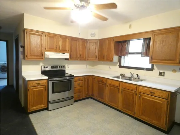 a kitchen with a sink cabinets stainless steel appliances and a window