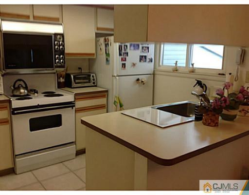 273 B Convent Road Monroe Township, NJ 08831 - Photo 5 of 15 a kitchen with kitchen island a sink a stove and a microwave