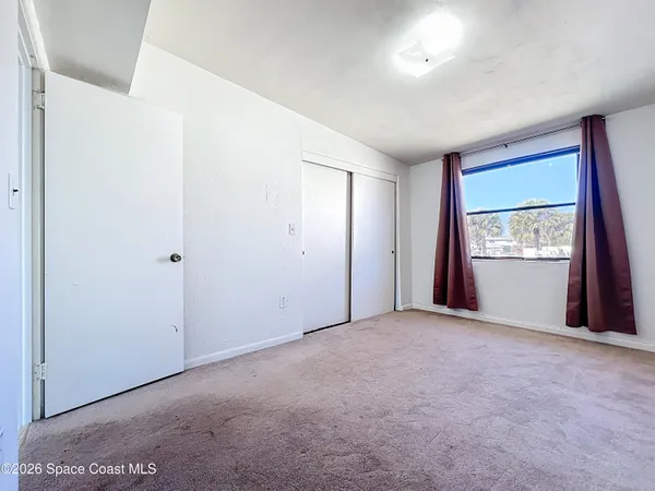 an empty room with windows and closet