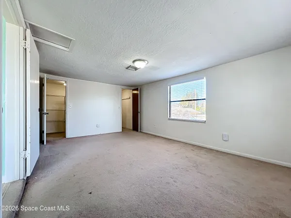 an empty room with windows and closet