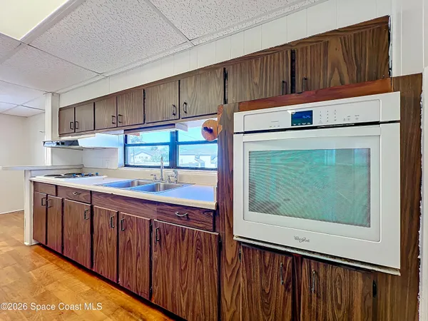 a kitchen with stainless steel appliances granite countertop a refrigerator a stove and a sink with wooden cabinets