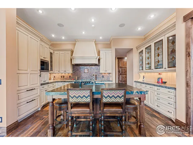 a kitchen with granite countertop a table chairs stove and cabinets