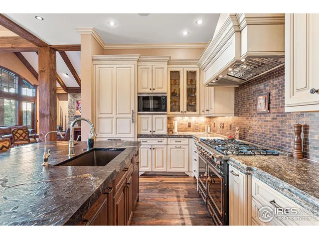 a kitchen with granite countertop a stove a sink and a wooden cabinets