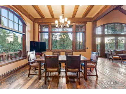 a view of a dining room with furniture a chandelier and wooden floor