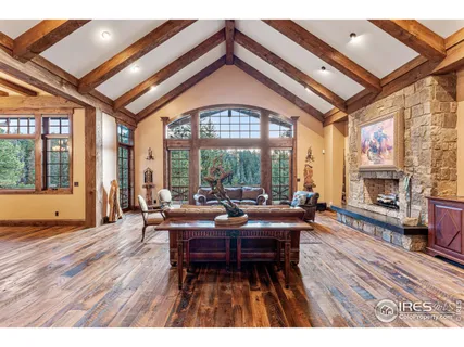 a living room with furniture a fireplace and floor to ceiling windows