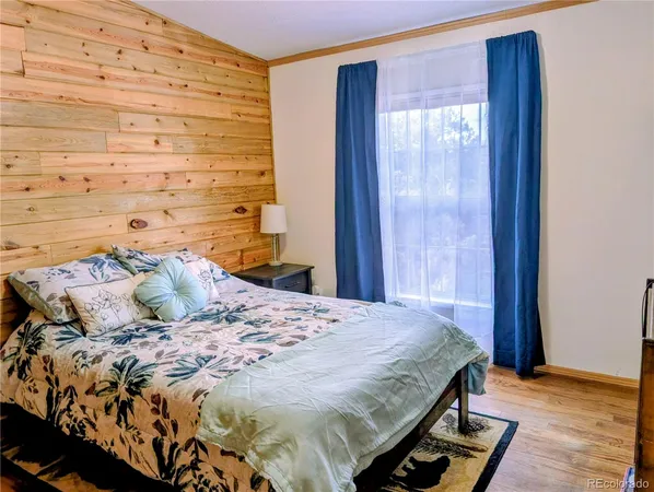 a bedroom with a bed and a wooden floor
