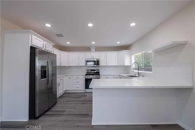 a large kitchen with kitchen island a sink stainless steel appliances and cabinets