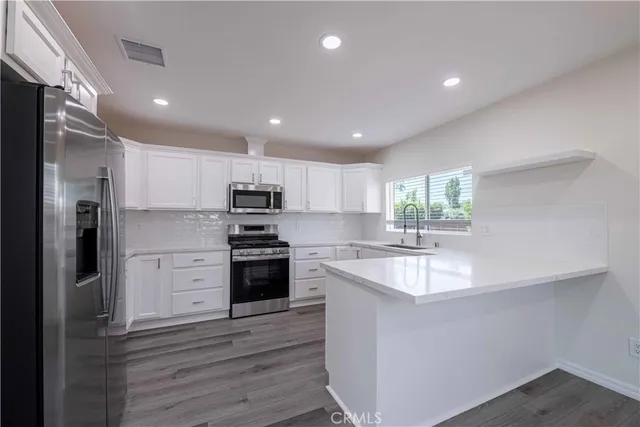 a kitchen with a sink stainless steel appliances and window