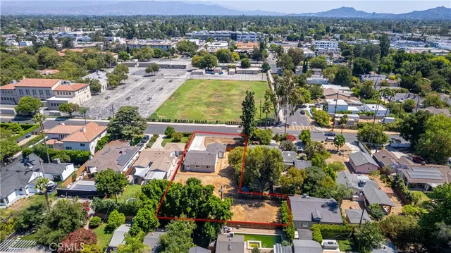 an aerial view of a house with a yard and large trees