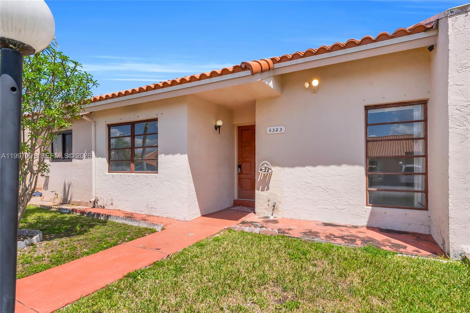 6323 Southwest 147th Pl Circle Miami, FL 33193 - Photo 2 of 29 a front view of a house with a yard