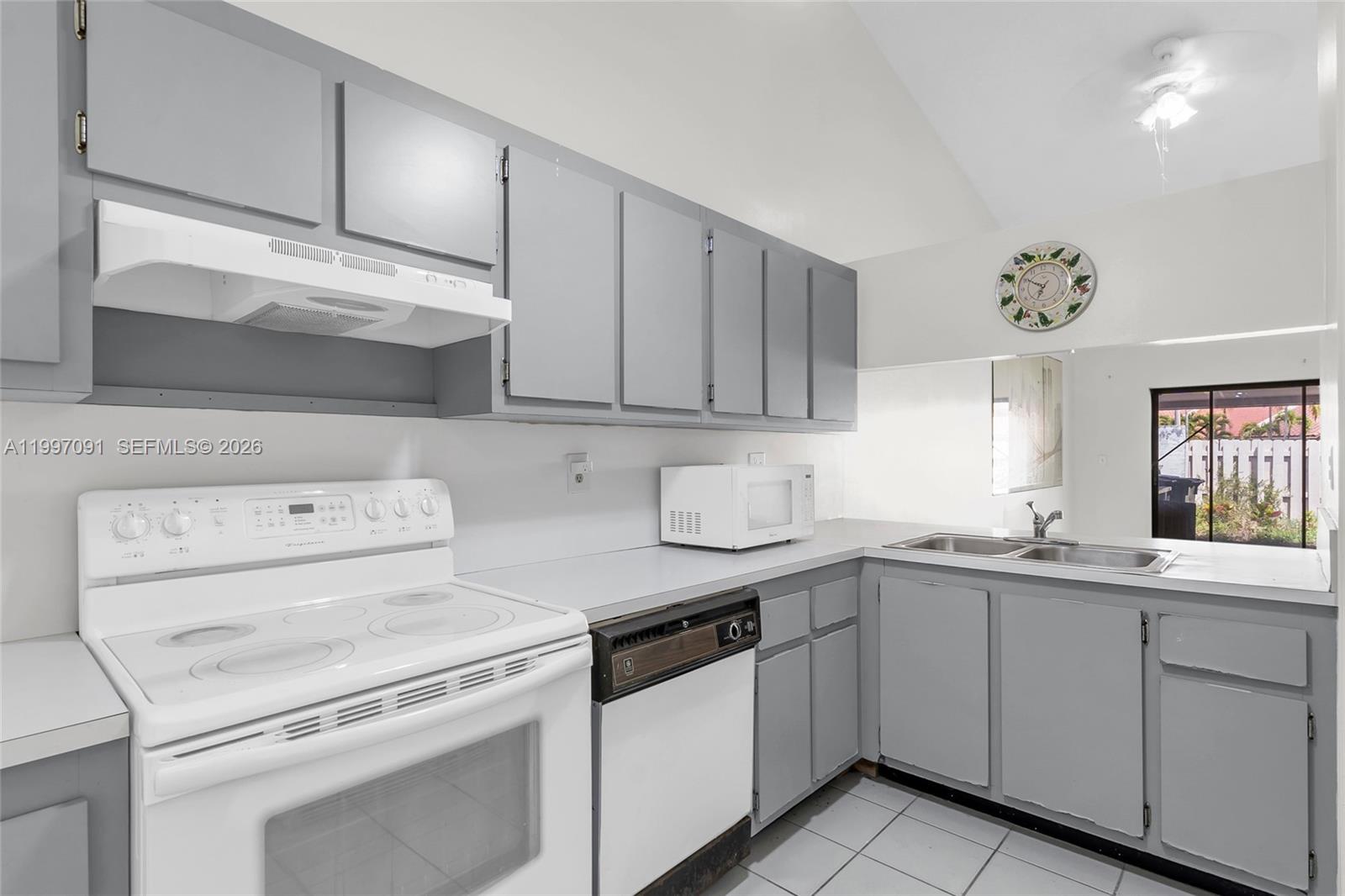 6323 Southwest 147th Pl Circle Miami, FL 33193 - Photo 10 of 29 a kitchen with white cabinets and white appliances
