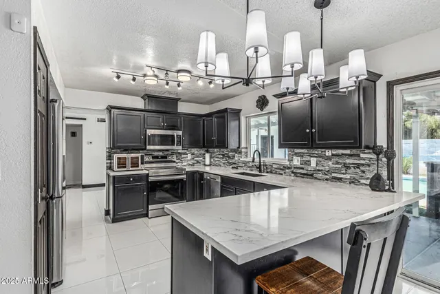 a kitchen with stainless steel appliances granite countertop a sink a stove and a refrigerator