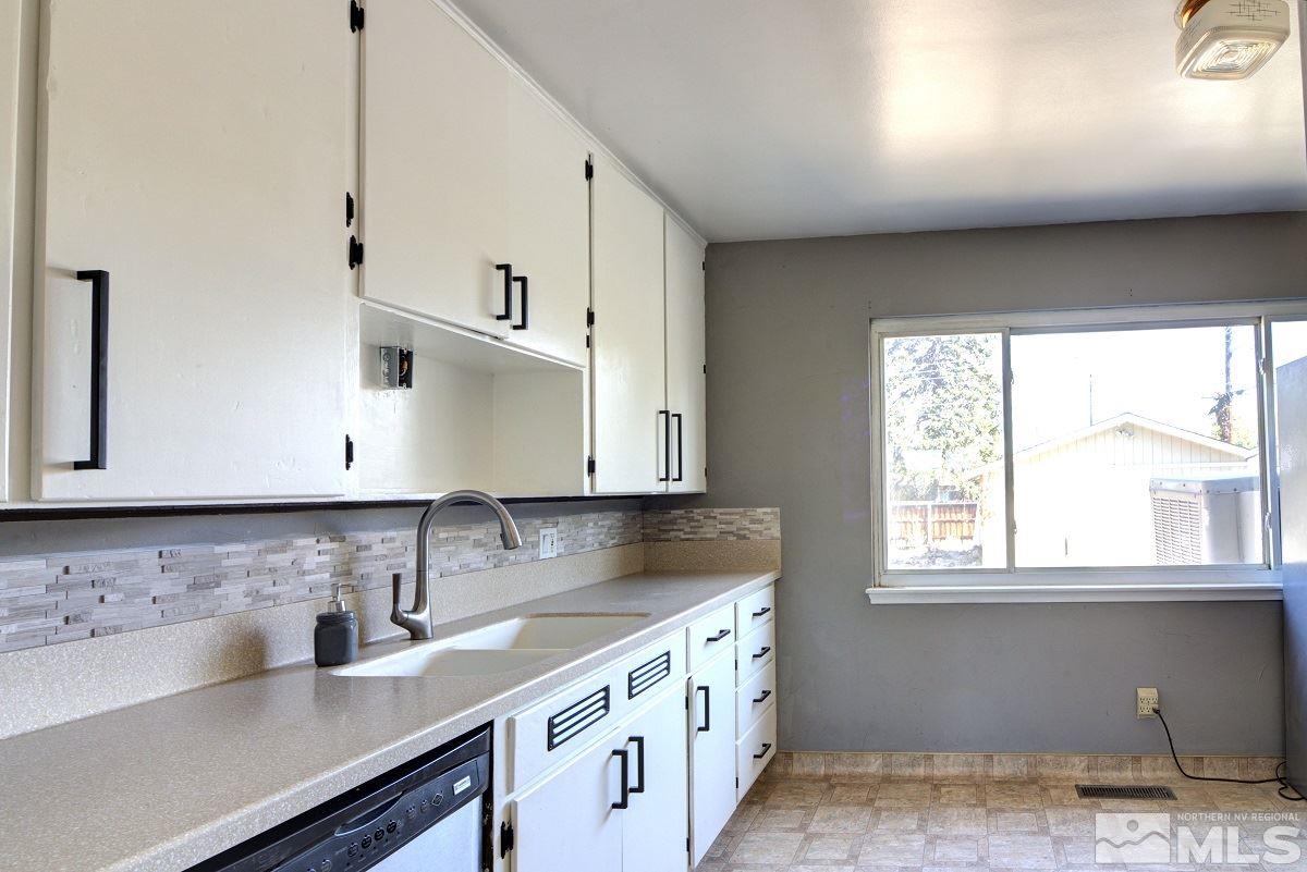 650 Lester Avenue Reno, NV 89502 - Photo 5 of 15 a kitchen with stainless steel appliances granite countertop a sink a stove and a microwave